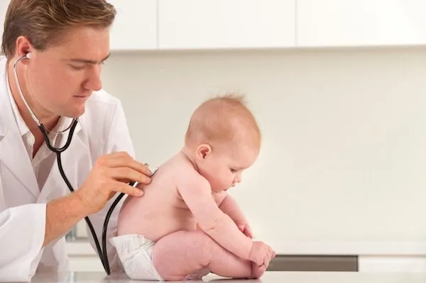 Serious doctor checks babys heartbeat and lungs